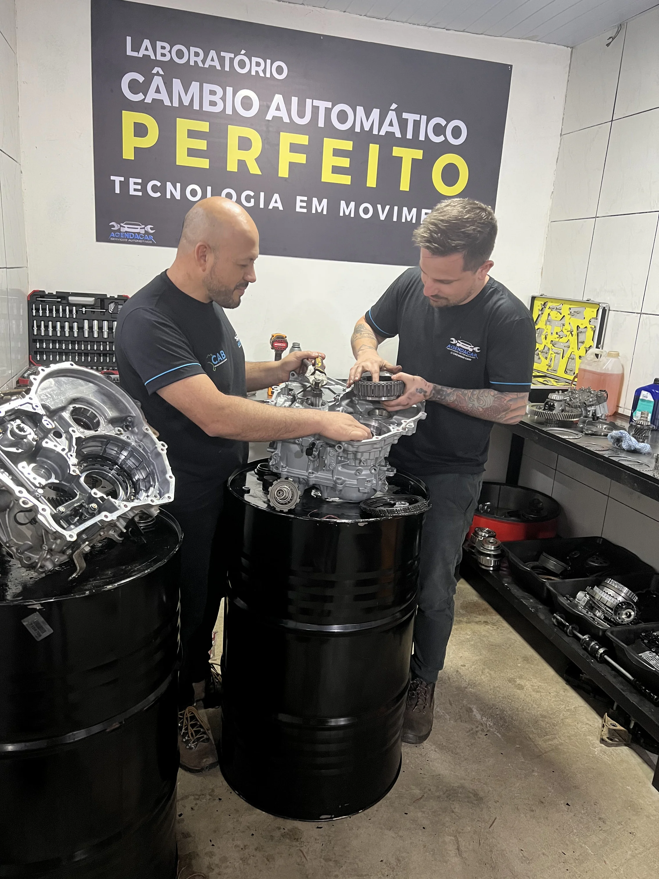 Técnicos remontando câmbio automático em cima de bancada no Laboratório AgendaCar